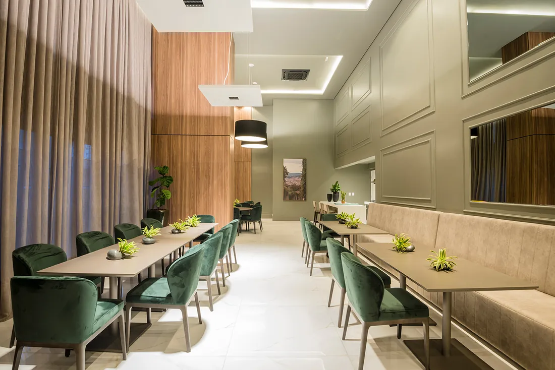 Salão gourmet com mesas e poltronas